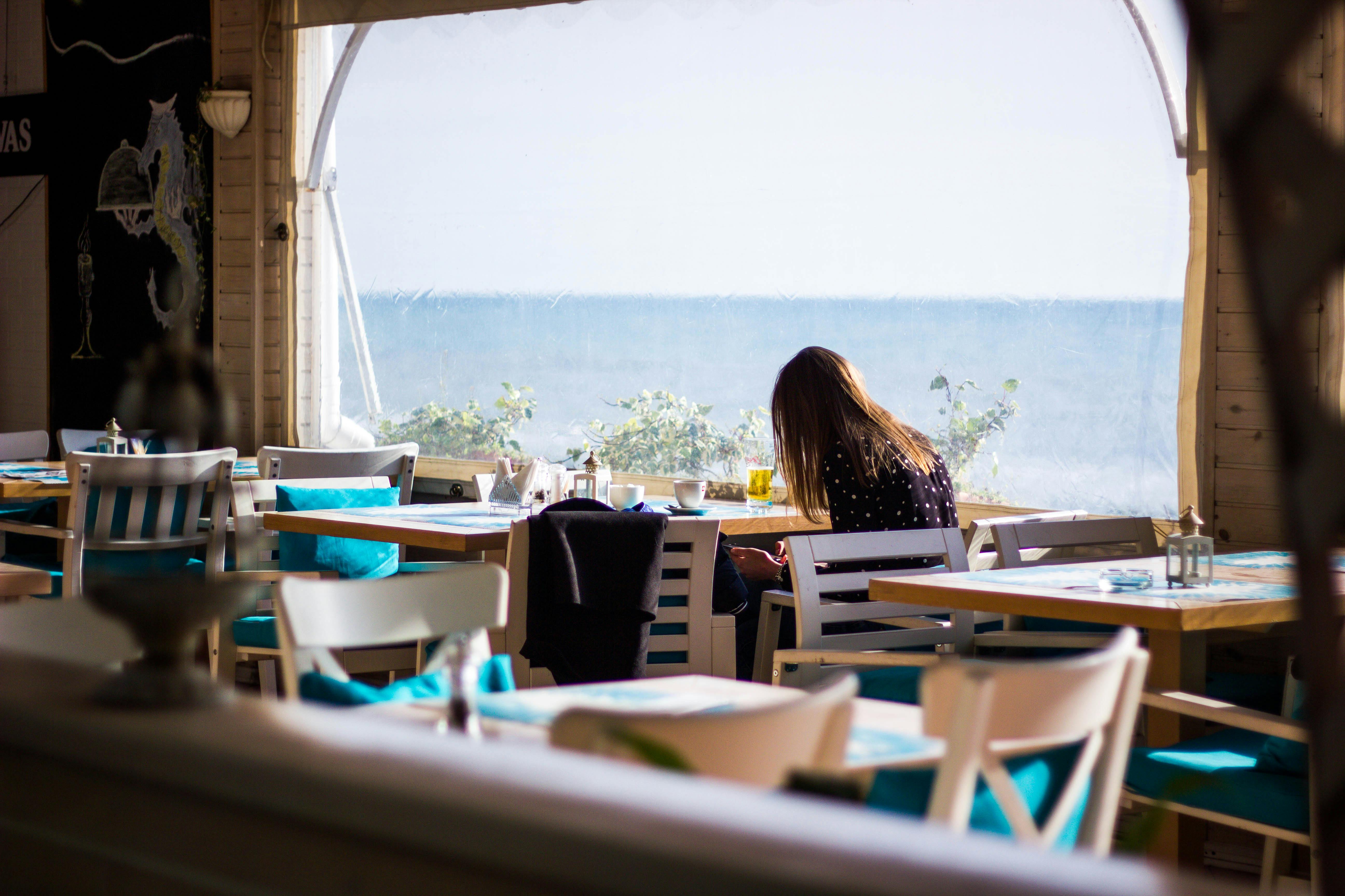 pexels-photo-914390-914390 A serene indoor café with a view of the ocean, perfect for relaxation.